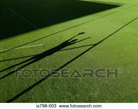 Stock Image - Shadow of rugby player and rugby post. Fotosearch