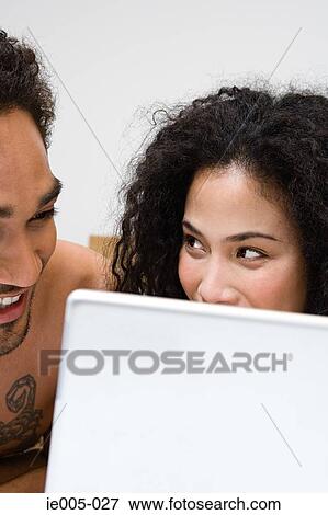 Couple using laptop View Large Photo Image Stock Photo - Couple using laptop. Fotosearch