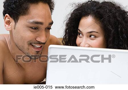 Stock Photography - Couple using laptop. Fotosearch