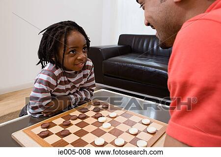 Father and son playing draughts View Large Photo Image Stock Photo - Father and son playing draughts. Fotosearch