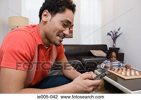 Stock Image - Young man using cell phone. Fotosearch