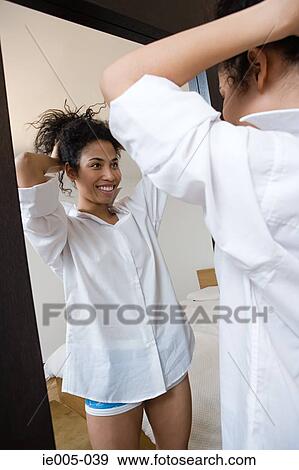 Young woman styling hair View Large Photo Image Stock Photo - Young woman styling hair. Fotosearch