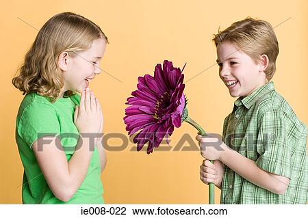 Boy giving flower to girl View Large Photo Image Stock Image - Boy giving flower to girl. Fotosearch