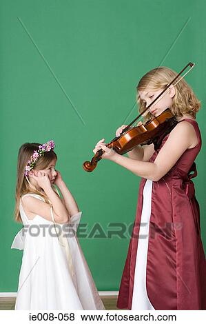 Girl playing violin to sister View Large Photo Image Stock Photo - Girl playing violin to sister. Fotosearch