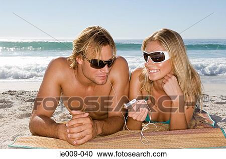 Stock Image - Couple listening to mp3 player. Fotosearch