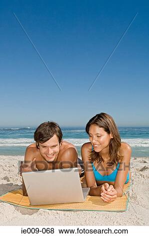 Couple using laptop View Large Photo Image Stock Photo - Couple using laptop. Fotosearch
