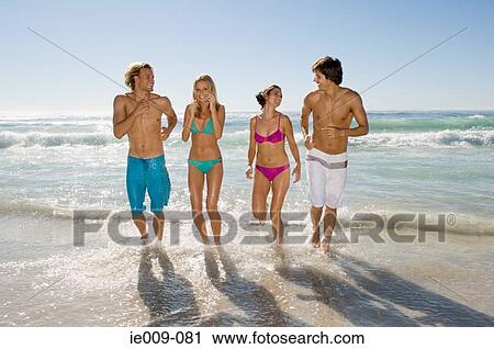Stock Image - Friends running in the sea. Fotosearch