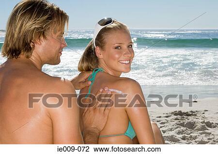 Man applying suncream onto womans back View Large Photo Image Stock Image - Man applying suncream onto womans back. Fotosearch