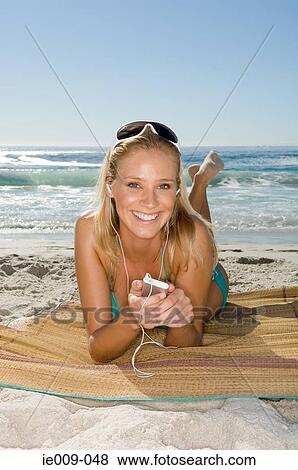 Young woman listening to mp3 player View Large Photo Image Stock Photo - Young woman listening to mp3 player. Fotosearch