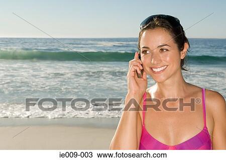 Stock Image - Young woman using cell phone. Fotosearch
