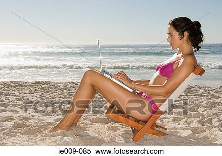 Young woman using laptop View Large Photo Image Stock Photography - Young woman using laptop. Fotosearch