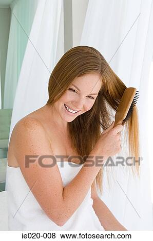 Stock Photo - Young woman brushing hair. Fotosearch
