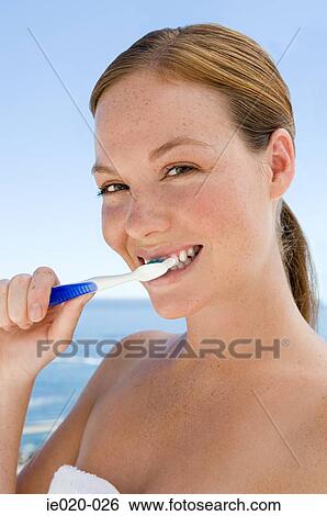 Stock Photograph - Young woman brushing teeth. Fotosearch