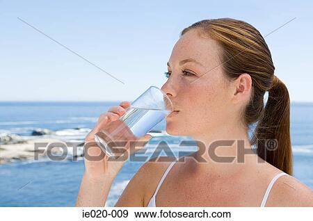 Young woman drinking water View Large Photo Image Stock Photo - Young woman drinking water. Fotosearch
