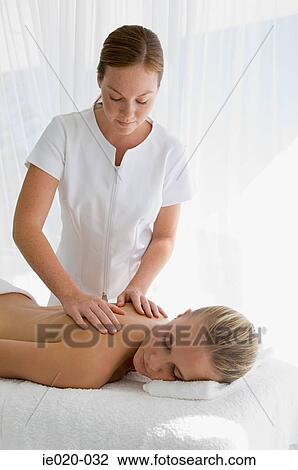 Young woman having back massaged View Large Photo Image Stock Image - Young woman having back massaged. Fotosearch