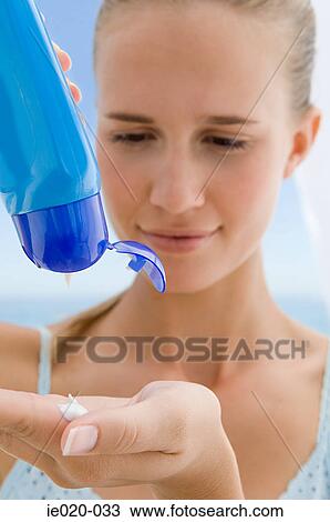 Young woman pouring suncream into hand View Large Photo Image Stock Image - Young woman pouring suncream into hand. Fotosearch