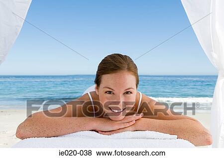 Stock Photo - Young woman relaxing on a beach. Fotosearch