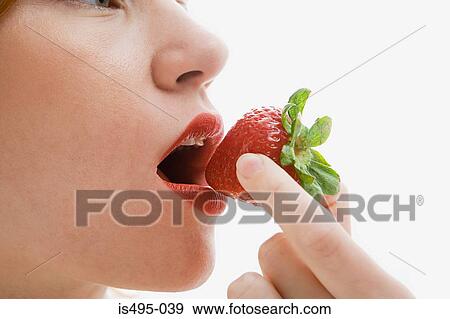 Stock Photo - Woman eating a strawberry. Fotosearch