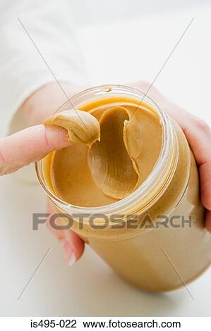 Woman scooping peanut butter from jar View Large Photo Image Stock Image - Woman scooping peanut butter from jar. Fotosearch