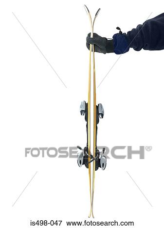 Stock Photo - Person holding a pair of skis. Fotosearch