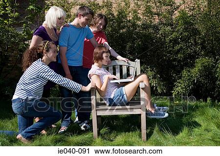 Stock Image - Friends looking at a laptop. Fotosearch
