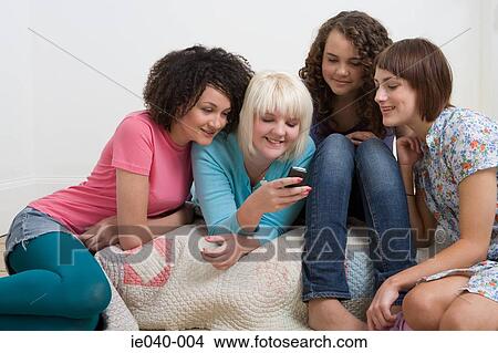 Friends looking at cell phone View Large Photo Image Picture - Friends looking at cell phone. Fotosearch