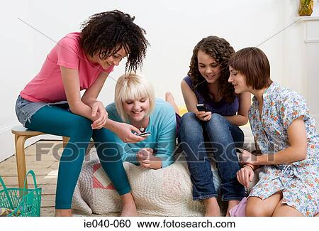 Stock Image - Friends looking at cell phone. Fotosearch