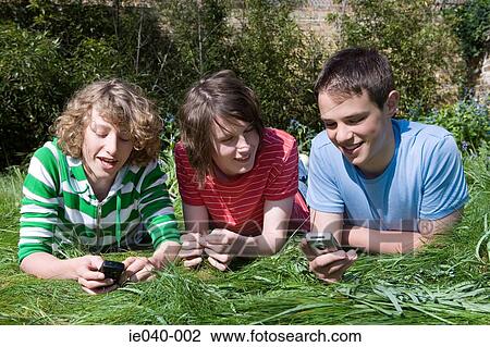 Stock Image - Friends using their cell phones. Fotosearch