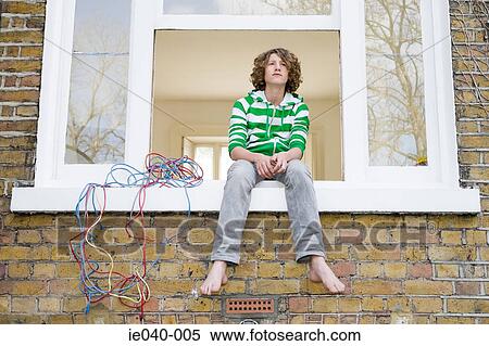 Teenage boy sat on windowsill View Large Photo Image Stock Photography - Teenage boy sat on windowsill. Fotosearch
