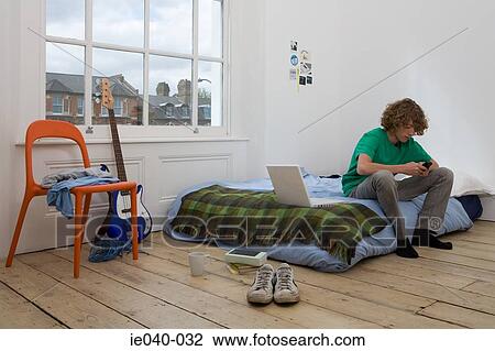 Teenage boy using cell phone View Large Photo Image Stock Image - Teenage boy using cell phone. Fotosearch