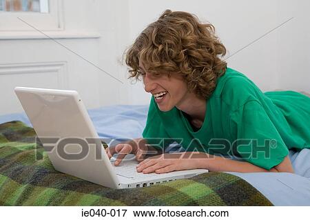 Teenage boy using laptop View Large Photo Image Stock Photo - Teenage boy using laptop. Fotosearch