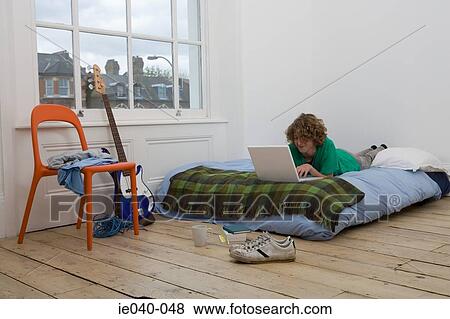 Teenage boy using laptop View Large Photo Image Stock Photo - Teenage boy using laptop. Fotosearch
