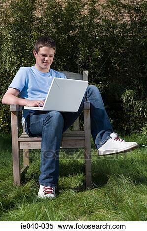 Teenage boy using laptop View Large Photo Image Stock Photography - Teenage boy using laptop. Fotosearch