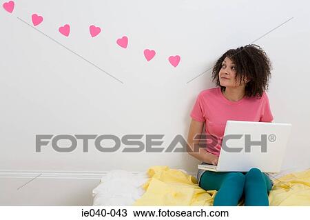 Stock Image - Teenage girl using laptop. Fotosearch
