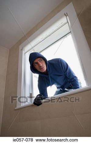 A burglar climbing through a window View Large Photo Image Stock Photo - A burglar climbing through a window. Fotosearch