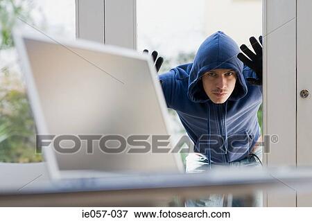 A burglar looking through a glass door View Large Photo Image Stock Photo - A burglar looking through a glass door. Fotosearch