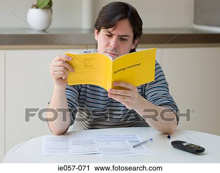 Stock Image - A man reading an insurance leaflet. Fotosearch