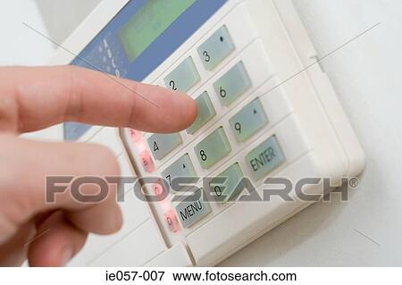 Stock Photo - A person setting a burglar alarm. Fotosearch