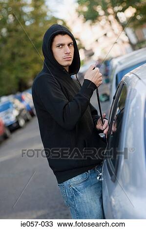 A thief breaking into a car View Large Photo Image Stock Image - A thief breaking into a car. Fotosearch