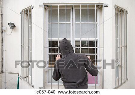 A thief looking through a window View Large Photo Image Stock Image - A thief looking through a window. Fotosearch