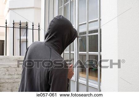 A thief looking through a window View Large Photo Image Stock Image - A thief looking through a window. Fotosearch