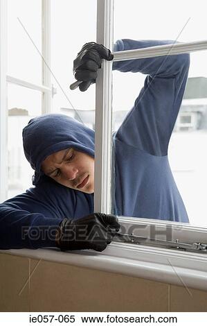 Stock Photography - A thief opening a window. Fotosearch