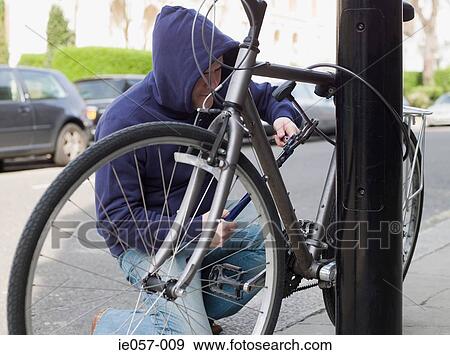 Stock Photo - A thief stealing a bike. Fotosearch