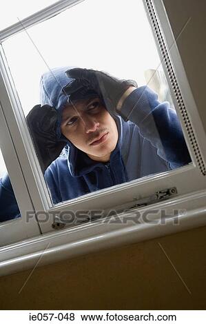 Burglar looking through window View Large Photo Image Stock Photo - Burglar looking through window. Fotosearch