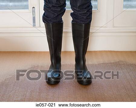Person wearing rubber boots on a wet carpet View Large Photo Image Stock Image - Person wearing rubber boots on a wet carpet. Fotosearch