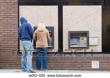 Thief looking over womans shoulder at cash machine View Large Photo Image Stock Photography - Thief looking over womans shoulder at cash machine. Fotosearch