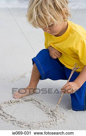 Boy drawing in the sand View Large Photo Image Stock Image - Boy drawing in the sand. Fotosearch