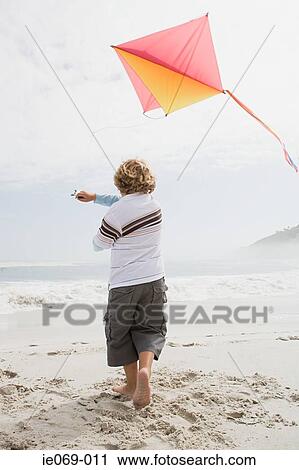 Boy flying a kite View Large Photo Image Stock Image - Boy flying a kite. Fotosearch