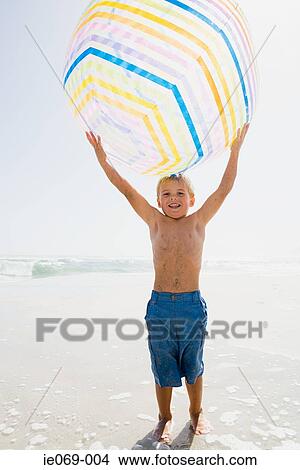 Boy holding a giant beachball View Large Photo Image Picture - Boy holding a giant beachball. Fotosearch