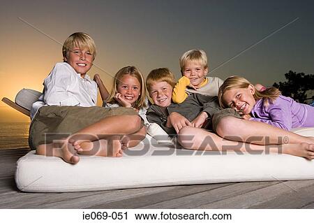 Stock Image - Boys and girls relaxing. Fotosearch